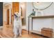 Welcoming entryway with hardwood floors, a friendly dog, and a hallway leading to the bedrooms at 2001 Grove St, Denver, CO 80211