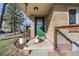 Inviting front porch with green door, brick accents, and a cute dog lounging in the sunshine at 2001 Grove St, Denver, CO 80211
