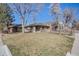 Exterior view of a well-maintained brick home with a fenced yard and mature trees at 2001 Grove St, Denver, CO 80211