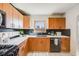 Well-lit kitchen features wood cabinets, white countertops, a black backsplash, and modern appliances at 2001 Grove St, Denver, CO 80211