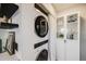 Modern laundry area with stacked washer and dryer and a cabinet with glass doors for storage at 2001 Grove St, Denver, CO 80211