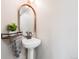Chic powder room with a pedestal sink, stylish lighting, and a modern mirror for a minimalist aesthetic at 2001 Grove St, Denver, CO 80211