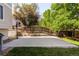 Backyard concrete sport court with basketball hoop surrounded by a wood fence and mature shade trees at 15963 Rock Crystal Dr, Parker, CO 80134