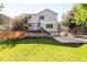 Exterior view of backyard featuring large manicured lawn, wood deck, and concrete sport court at 15963 Rock Crystal Dr, Parker, CO 80134