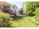 Spacious backyard featuring lush green grass and concrete sport court with mature trees at 15963 Rock Crystal Dr, Parker, CO 80134