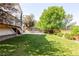 Well-manicured backyard with mature trees and a cement patio area, perfect for outdoor activities at 15963 Rock Crystal Dr, Parker, CO 80134