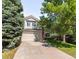 Charming two-story home with a manicured lawn, mature trees, and a two-car garage at 15963 Rock Crystal Dr, Parker, CO 80134