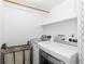 Efficient laundry room with modern front-load washer and dryer, shelving, and convenient storage at 15963 Rock Crystal Dr, Parker, CO 80134