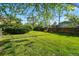Lush backyard featuring a large green lawn, mature trees, established landscaping and a wood fence at 1905 S Linden Ct, Denver, CO 80224