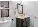 Bathroom features a vanity with a black cabinet, mirror, and decor at 1905 S Linden Ct, Denver, CO 80224