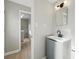 Bathroom featuring a black faucet, modern vanity, and an adjacent laundry area at 1905 S Linden Ct, Denver, CO 80224