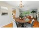Elegant dining area with hardwood floors, a chandelier, and an open view into the living room and kitchen at 1905 S Linden Ct, Denver, CO 80224