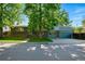Well-maintained two-story home with a spacious driveway, three car garage, mature trees, and a green lawn at 1905 S Linden Ct, Denver, CO 80224