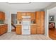Kitchen showcasing wooden cabinetry, white appliances, and tile flooring at 1905 S Linden Ct, Denver, CO 80224