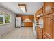 Spacious kitchen with wooden cabinets, tile flooring, and stainless steel dishwasher at 1905 S Linden Ct, Denver, CO 80224