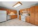 Traditional kitchen with wood cabinets, tile backsplash, tile flooring, and white appliances at 1905 S Linden Ct, Denver, CO 80224