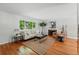 Bright living room featuring hardwood floors, a neutral color palette, fireplace, and large sun-filled window at 1905 S Linden Ct, Denver, CO 80224