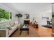 Cozy living room featuring large windows, a brick fireplace, and wood flooring at 1905 S Linden Ct, Denver, CO 80224