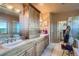 Well-lit bathroom featuring separate vanities, a tile floor, and wooden cabinets at 995 Nob Hill Rd, Evergreen, CO 80439