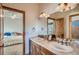 Bathroom features a double sink, wood cabinets, and a decorative backsplash at 995 Nob Hill Rd, Evergreen, CO 80439
