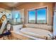Relaxing bathroom featuring a large tub, tiled shower, and a scenic mountain view at 995 Nob Hill Rd, Evergreen, CO 80439
