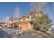 Two-story home with stone accents, a two-car garage, and beautiful trees in the yard at 995 Nob Hill Rd, Evergreen, CO 80439