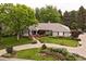 Landscaped front yard with circular driveway and mature trees framing the beautiful exterior of the home at 5340 S Logan Dr, Greenwood Village, CO 80121