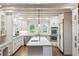Bright kitchen with white cabinets, stainless appliances, large island and hardwood floors at 5340 S Logan Dr, Greenwood Village, CO 80121
