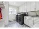 Well-organized laundry room with modern washer and dryer, ample cabinet space, and stylish tile flooring at 5340 S Logan Dr, Greenwood Village, CO 80121
