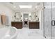 Spa-like bathroom featuring dual vanities, soaking tub, frameless shower, and skylight at 5340 S Logan Dr, Greenwood Village, CO 80121