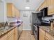 Functional kitchen equipped with stainless steel appliances, granite countertops, and wooden cabinets at 800 N Pearl St # 709, Denver, CO 80203