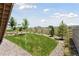 Grassy backyard with professional landscaping and a charming wooden fence at 13334 Blue Amber Ct, Parker, CO 80134