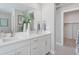 Bright bathroom featuring a double vanity with white cabinets, light countertops, and modern fixtures at 13334 Blue Amber Ct, Parker, CO 80134