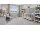 Cozy bedroom designed as a Bedroom, featuring a crib, rocking chair, and a serene view from the window at 13334 Blue Amber Ct, Parker, CO 80134