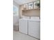 Clean, bright laundry room with washer, dryer, shelving, and decorative elements at 13334 Blue Amber Ct, Parker, CO 80134