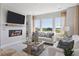 Living room with fireplace, built-in shelves, large windows, and comfortable seating at 13334 Blue Amber Ct, Parker, CO 80134