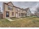 Street view of colorful townhomes featuring neat lawns, walkways, and varied architectural details at 14486 E Hawaii Cir # D, Aurora, CO 80012