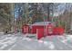 Two red outbuildings in snowy setting at 10658 Tallberg Ln, Conifer, CO 80433