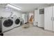 Basement laundry room with washer, dryer, utility sink, storage cabinets and staircase access at 1318 Ash St, Denver, CO 80220