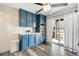 Beautiful laundry room featuring blue cabinets, wood counters, stylish tile backsplash, and stainless steel beverage refrigerator at 18143 E 104Th Way, Commerce City, CO 80022