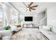 Bright living room with a ceiling fan, large windows, and modern furniture at 18143 E 104Th Way, Commerce City, CO 80022