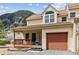 Charming two-story townhouse with covered porch and attached garage, set against a mountain view at 1795 Mountain Creek Dr, Georgetown, CO 80444