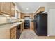 Well-lit kitchen with oak cabinets, laminate countertops, and black appliances on hardwood floor at 1795 Mountain Creek Dr, Georgetown, CO 80444