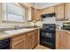 Well-lit kitchen featuring light wood cabinets, black appliances, and a double bowl sink with laminate countertops at 1795 Mountain Creek Dr, Georgetown, CO 80444