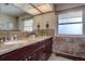 Bathroom featuring granite countertop, double sinks, and natural light from two windows at 7890 W 43Rd Pl, Wheat Ridge, CO 80033