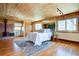 Spacious bedroom featuring wood-paneled walls, wood ceiling, fireplace, and hardwood floors at 7890 W 43Rd Pl, Wheat Ridge, CO 80033