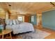 Bedroom featuring wood-paneled walls, wood ceiling, hardwood floors, and a large rug at 7890 W 43Rd Pl, Wheat Ridge, CO 80033