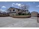 Exterior view of a two-story home featuring an attached garage, and circular brick wall at 7890 W 43Rd Pl, Wheat Ridge, CO 80033