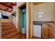 Hallway featuring stairs, mini bar with countertop, wood paneling, and tile flooring at 7890 W 43Rd Pl, Wheat Ridge, CO 80033