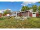 A cozy brick home with a large sunroom and a manicured lawn and picket fences at 8137 Vanguard Dr, Denver, CO 80221